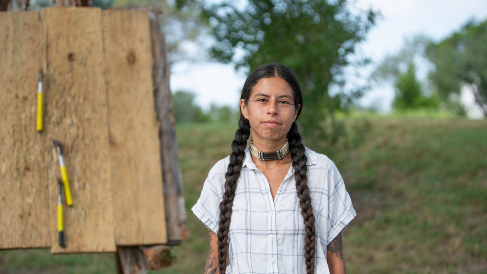 person wearing braids with native face tattoos