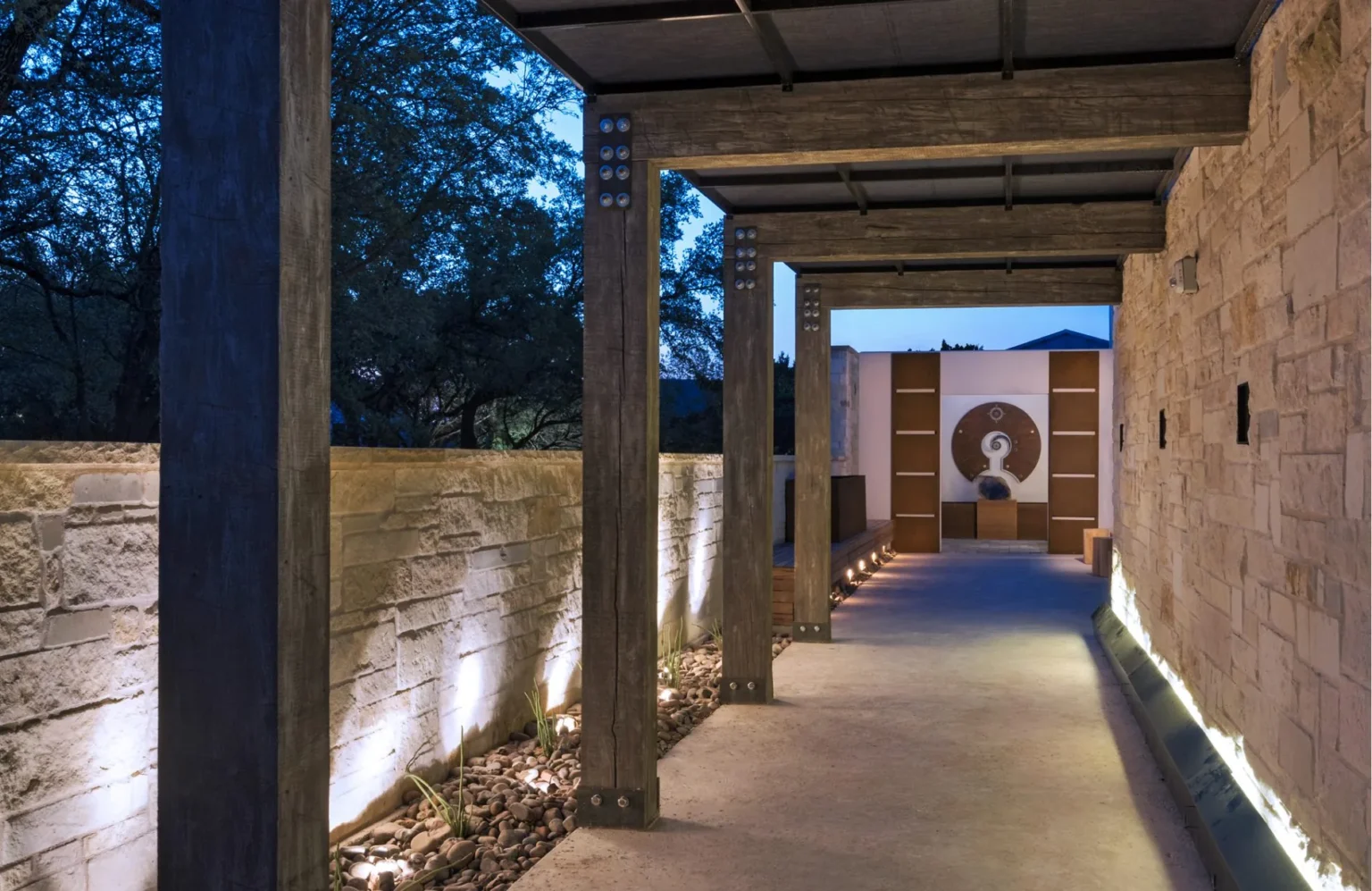 Stone and timber walkway lit at dusk