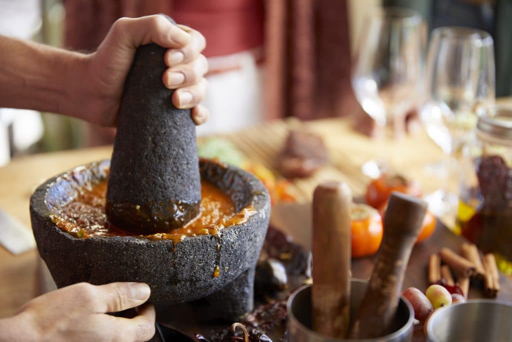 person grinding ingredients in a bowl