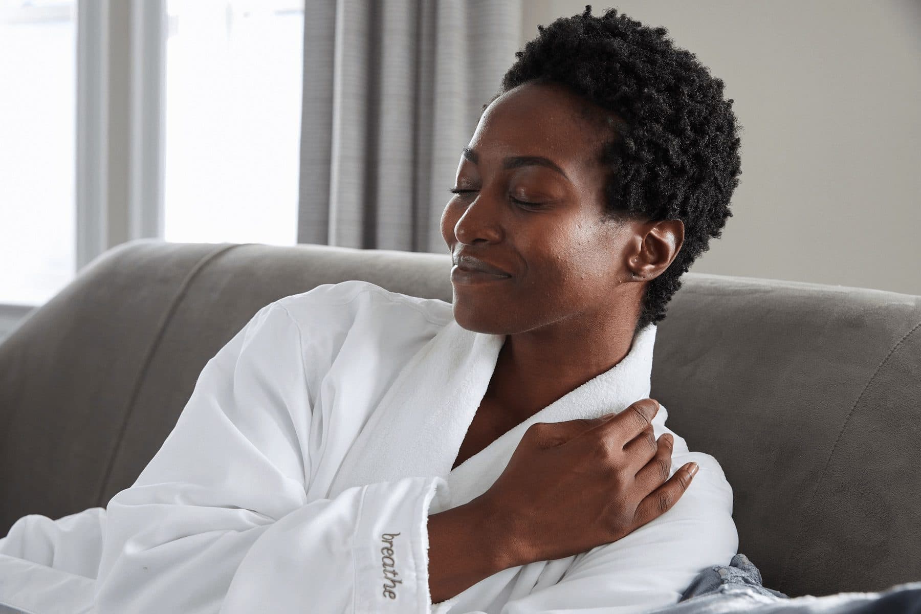 person relaxed in robe on couch