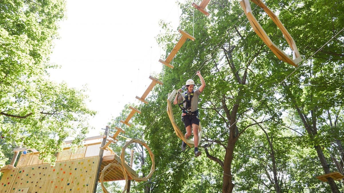 person walking on wires above the ground