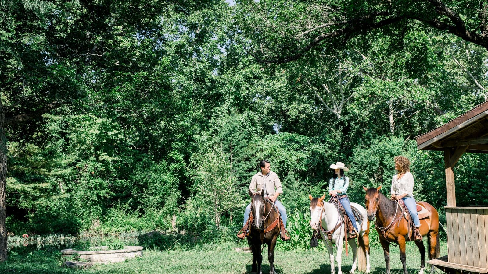 three people on horses outside