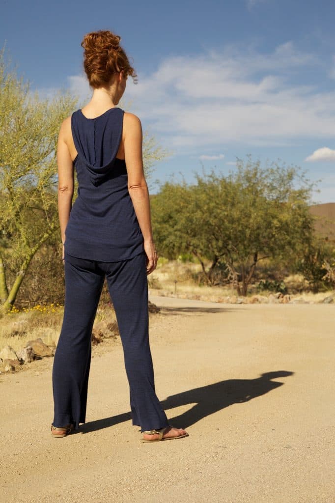 Woman standing on path in desert landscape looking on the ground