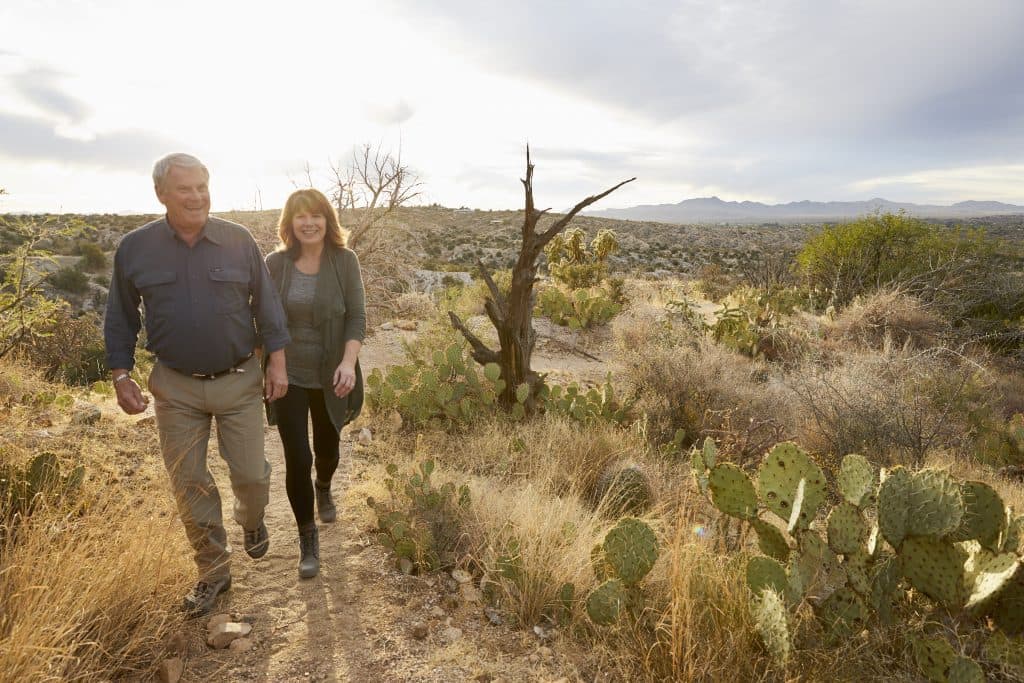 Smiling people walking on trail in desert