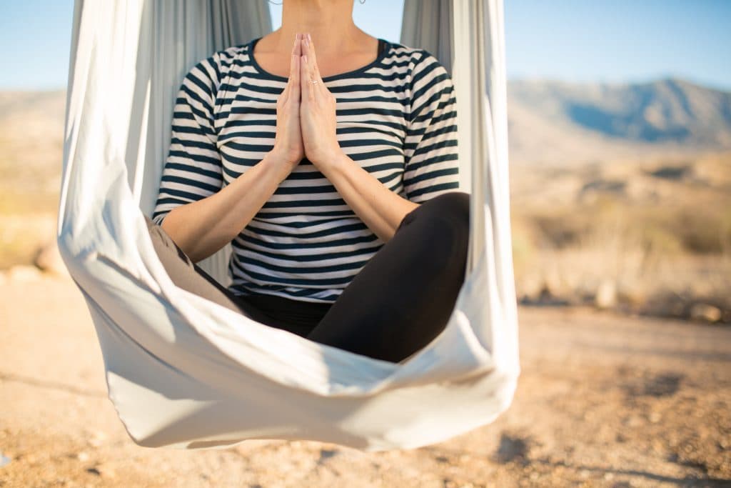 Womam sitting in swing doing yoga pose