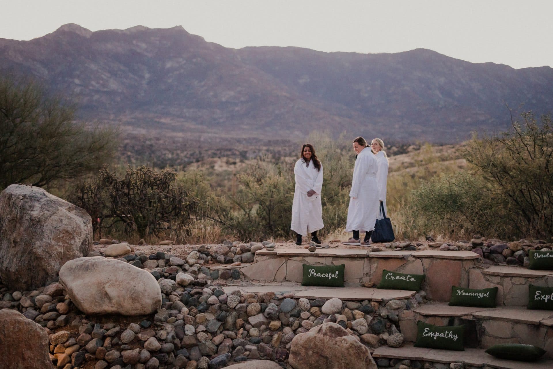 Group of women in robes outside in front of beautiful desert landscape