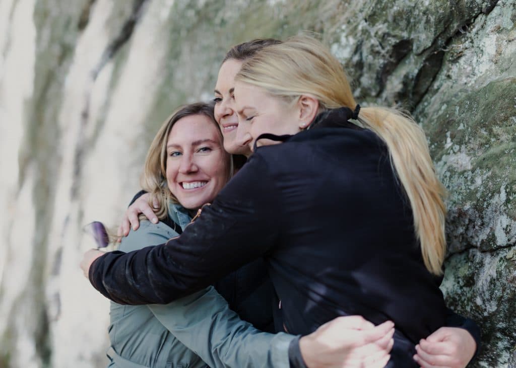 Three people hugging each other